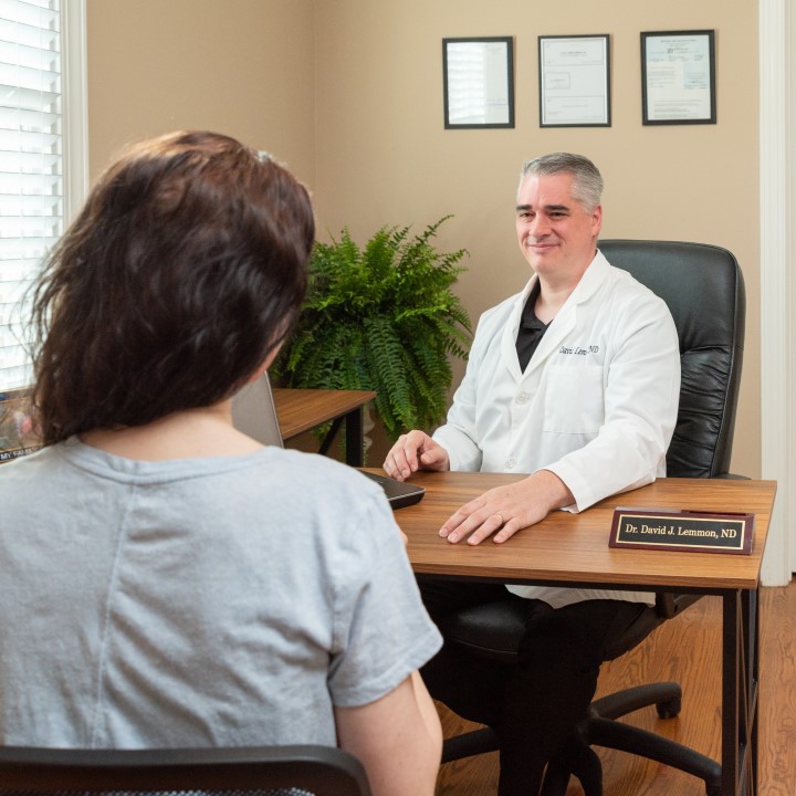 Dr. Lemmon talking with a visitor at his desk